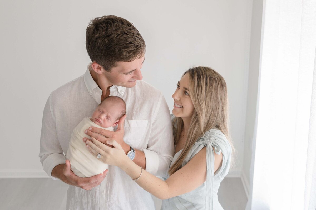 New Parents Gazing at Each Other Holding Baby Boy