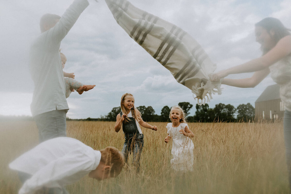 Family playing together in a prairie field.