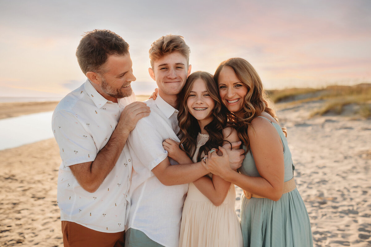 Family embraces for Beach Portraits in Isle of Palms.