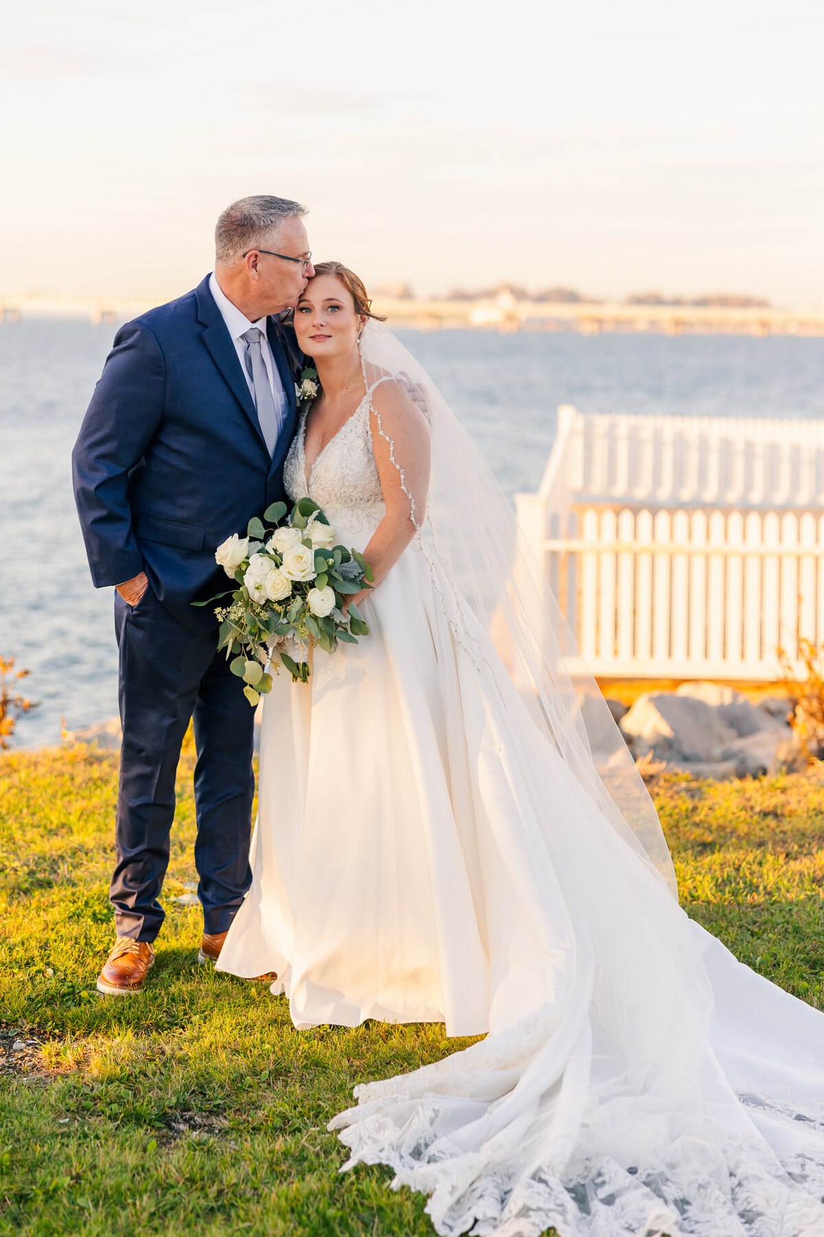 father of the bride kissing bride's forehead