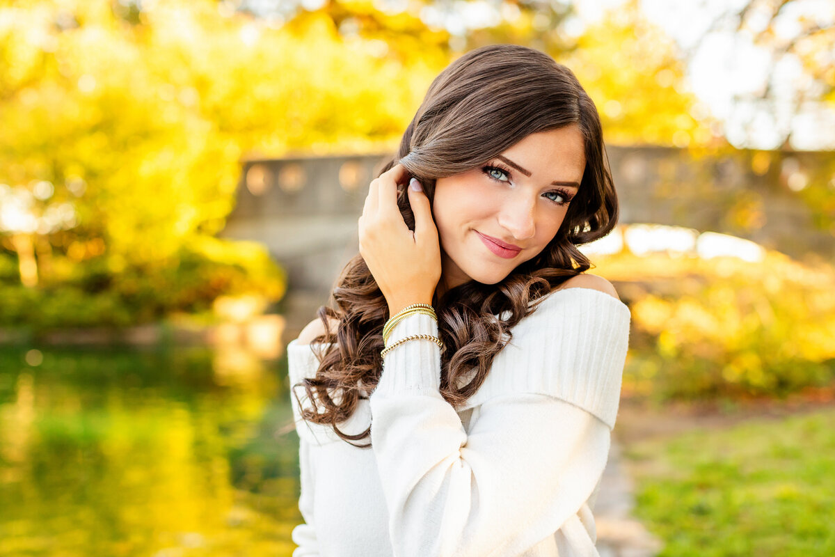 Senior girl in brush staring into camera with soft smile