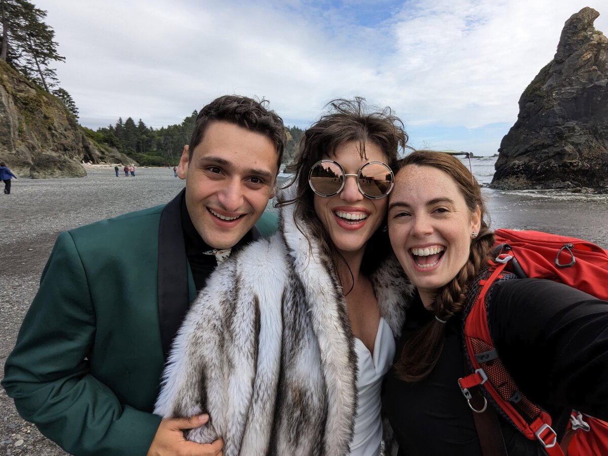 couple in theatre costume wedding attire smiling on beach with photographer after elopement in Washington