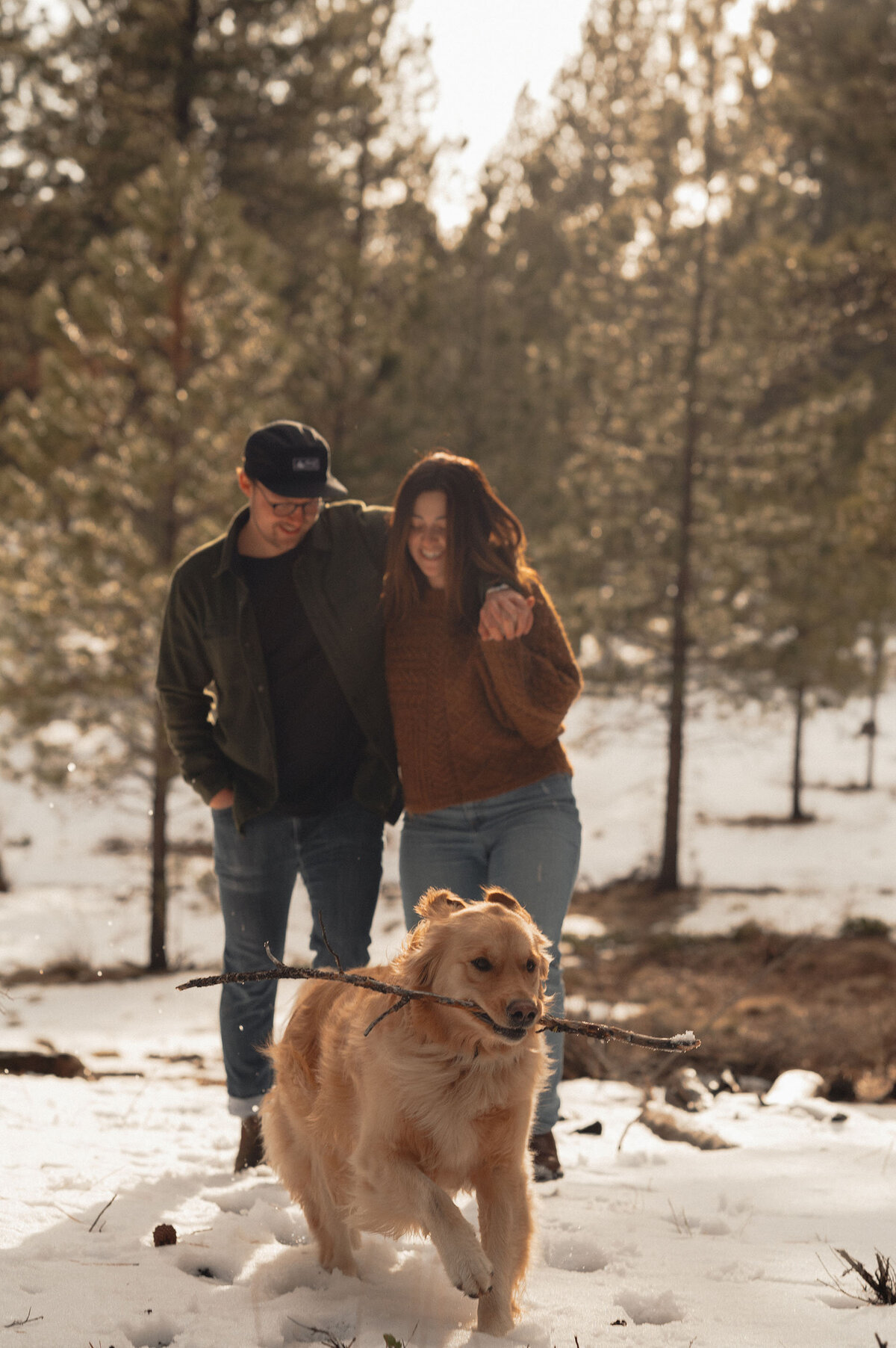 engagement couple hugging each other while walking on the trails in Bend, Oregon with their dog