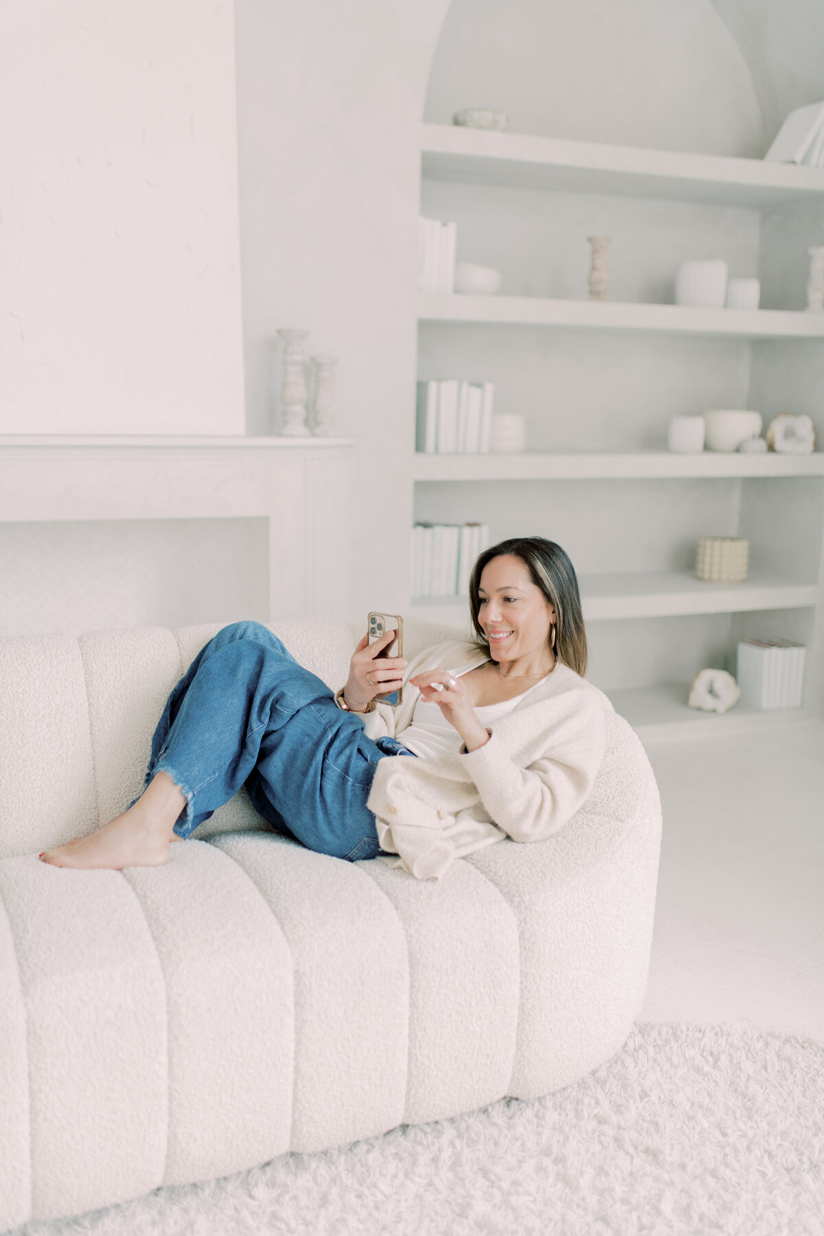 Entrepreneur in white attire seated elegantly, exuding calm authority.
