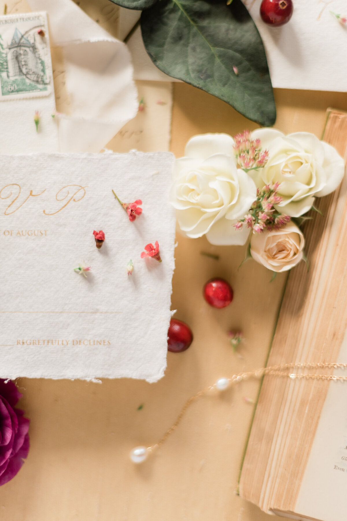 Romantic wedding stationery and details flatlay, styled by Wedding Stylist Rebekah Bronte, featuring vintage style wedding stationery and details, fruit, florals, and tones of honey, berry, green and brown. 