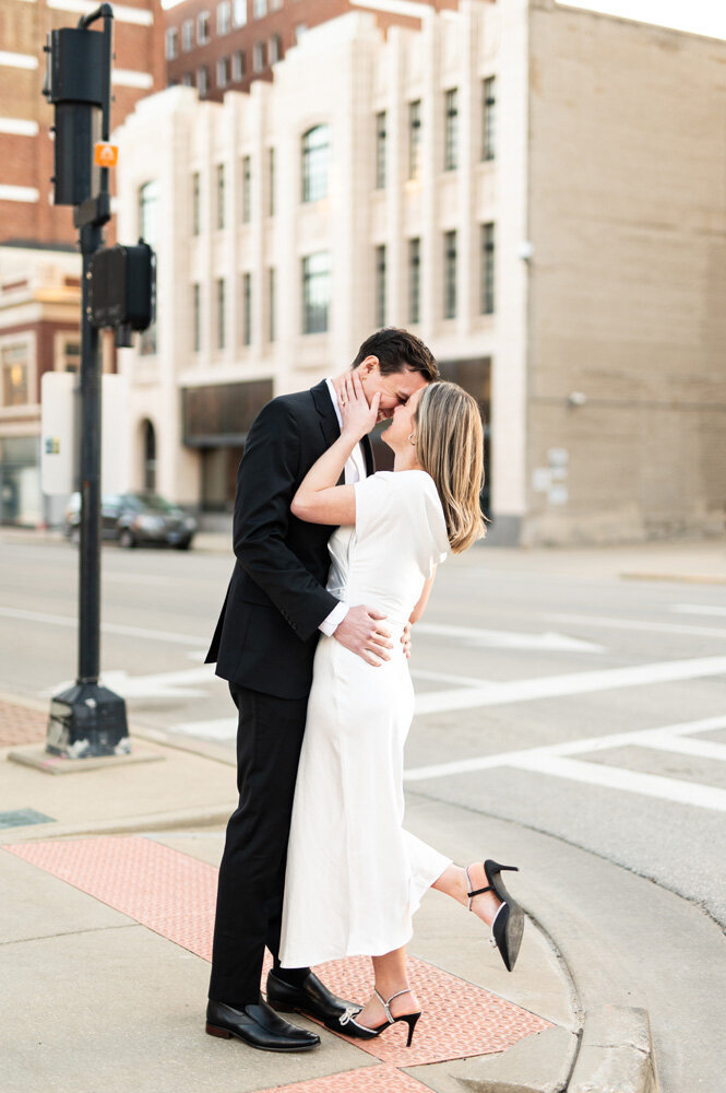 A couple kissing on the sidewalk