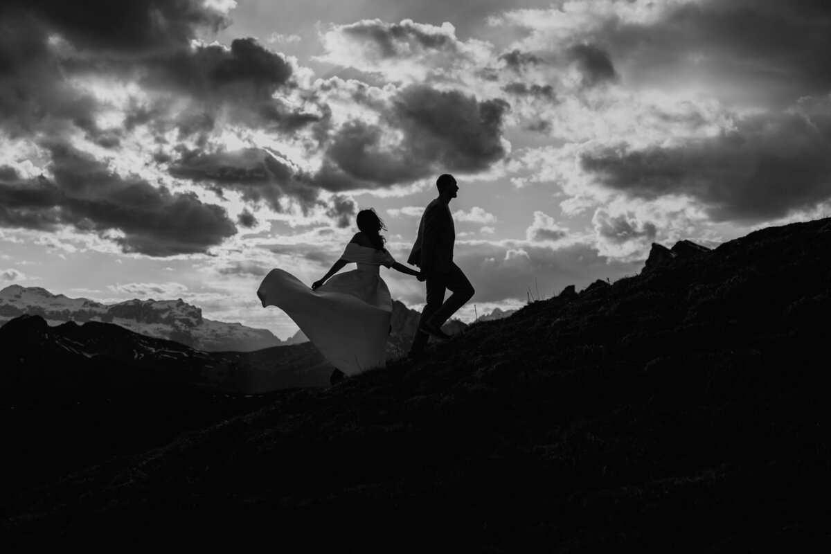 Black and white photo of couple walking together at sunset