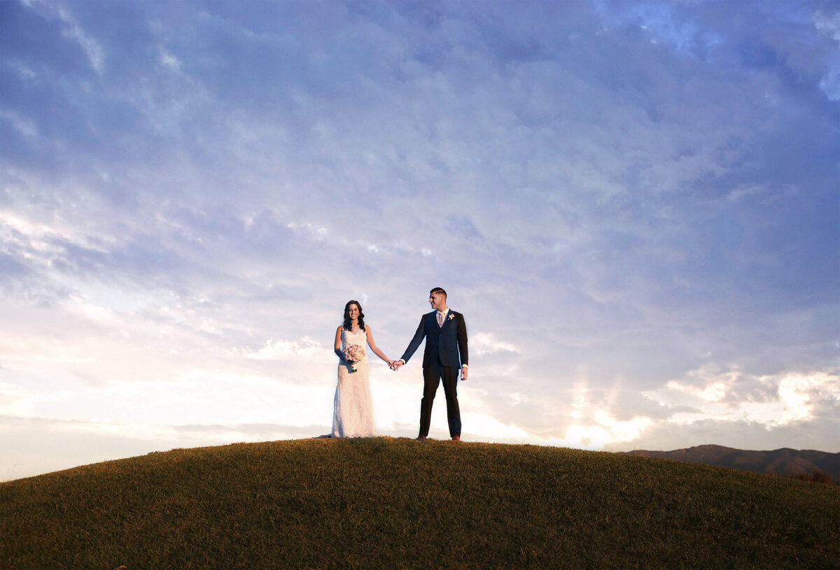 hilltop-wedding-portrait-bride-groom-holding-hands-sunset