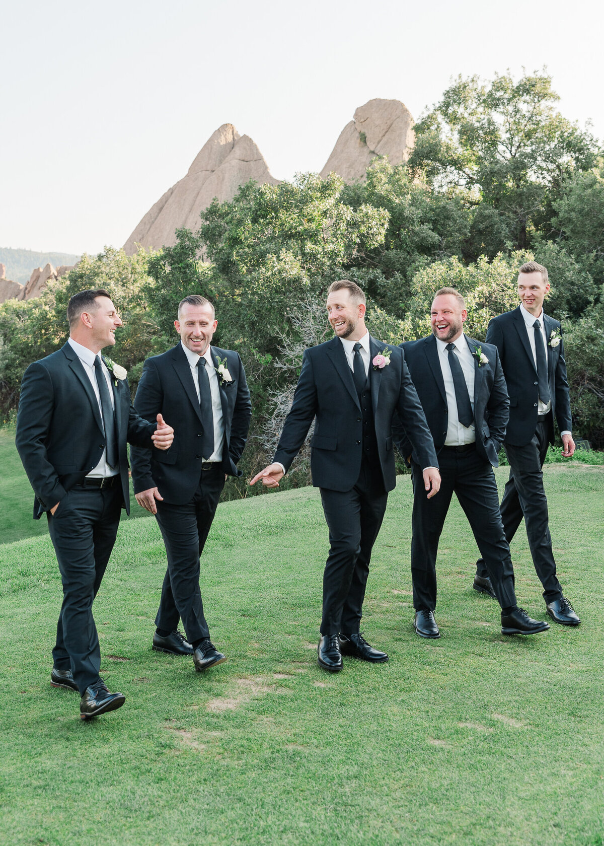 Denver wedding photographer captures groomsmen walking together candidly on a golf course