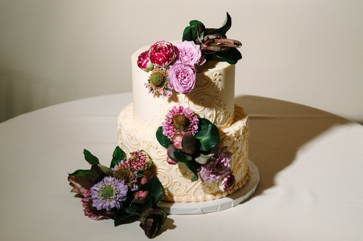 Close up of wedding cake with purple flowers