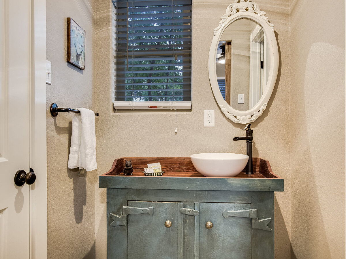 Small bathroom with green unit and white mirror