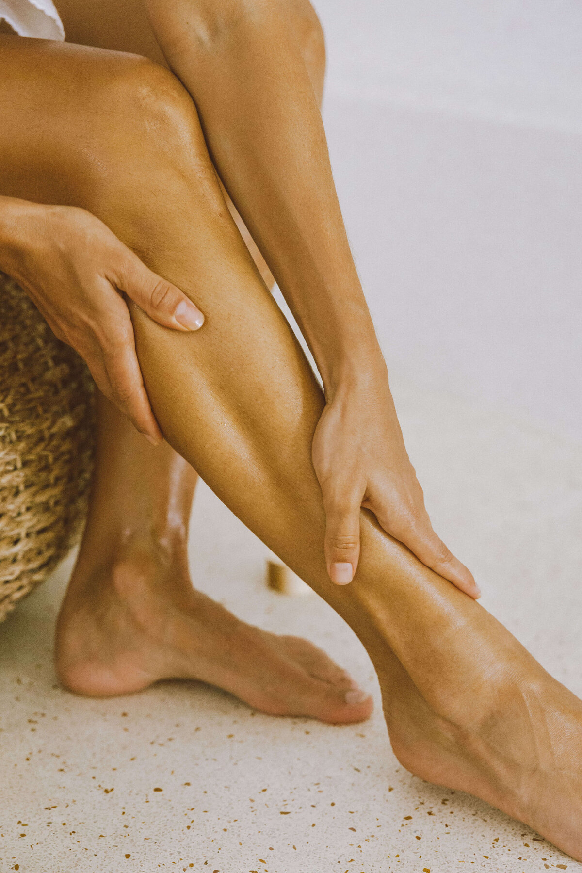 Skin care brand photography of woman applying moisturizing lotion to legs

