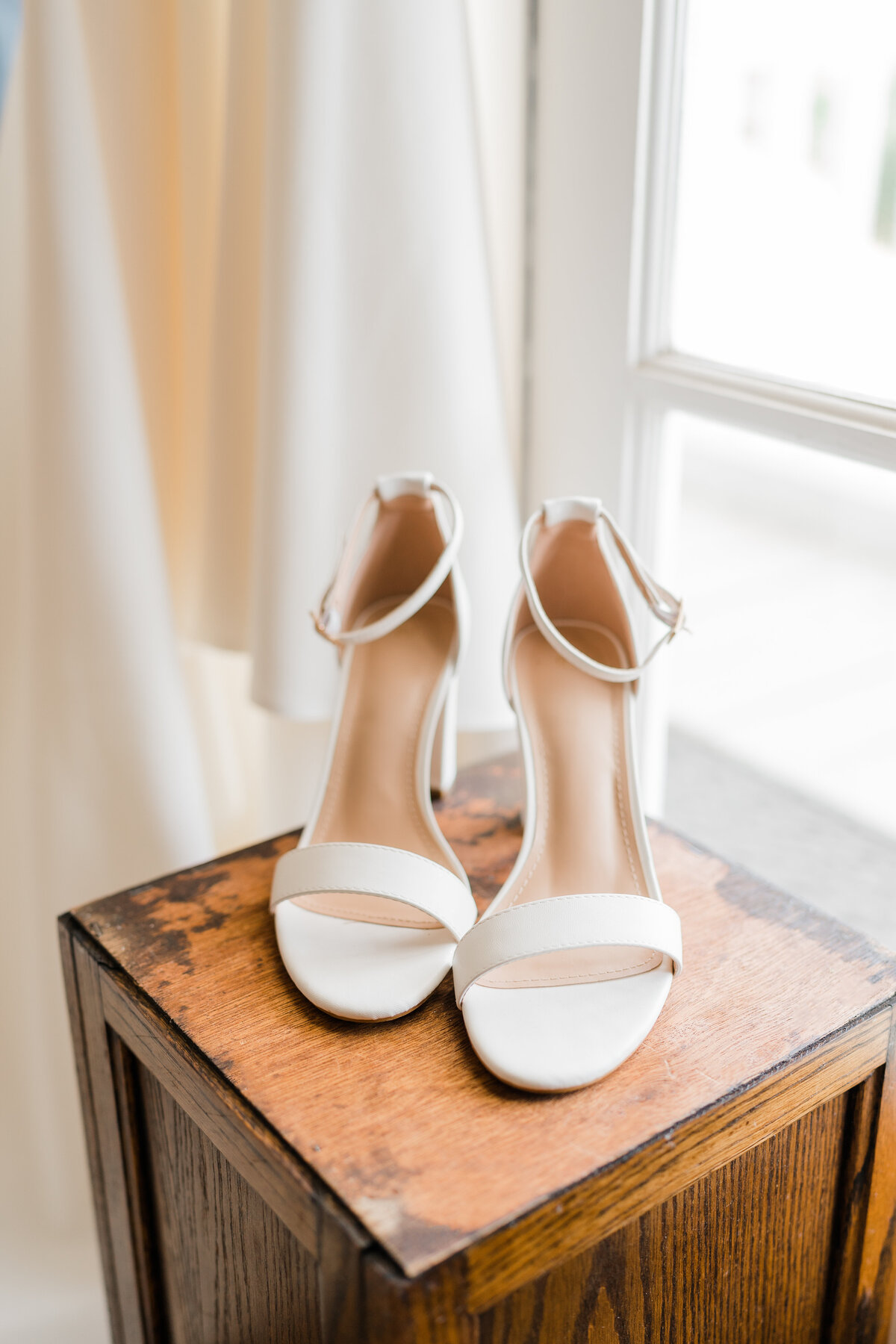 white open toed wedding heels on wooden box
