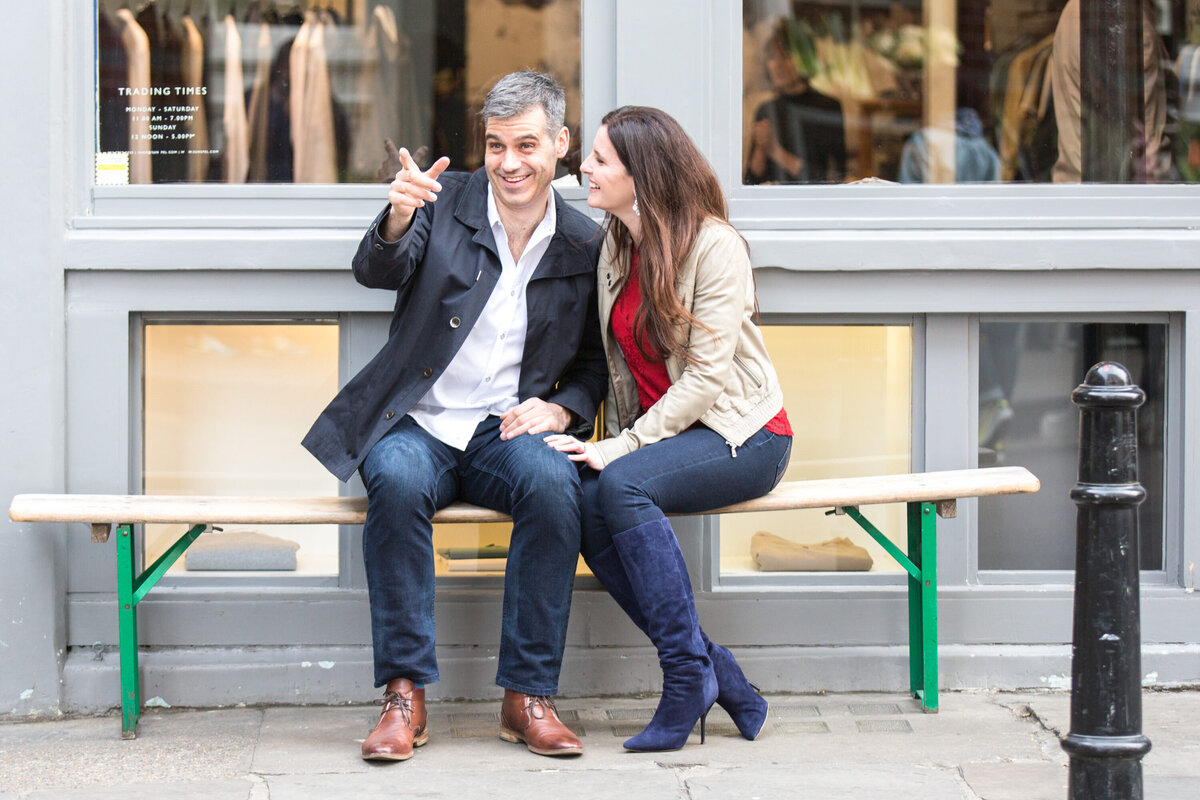 Man and woman on bench together with man pointing