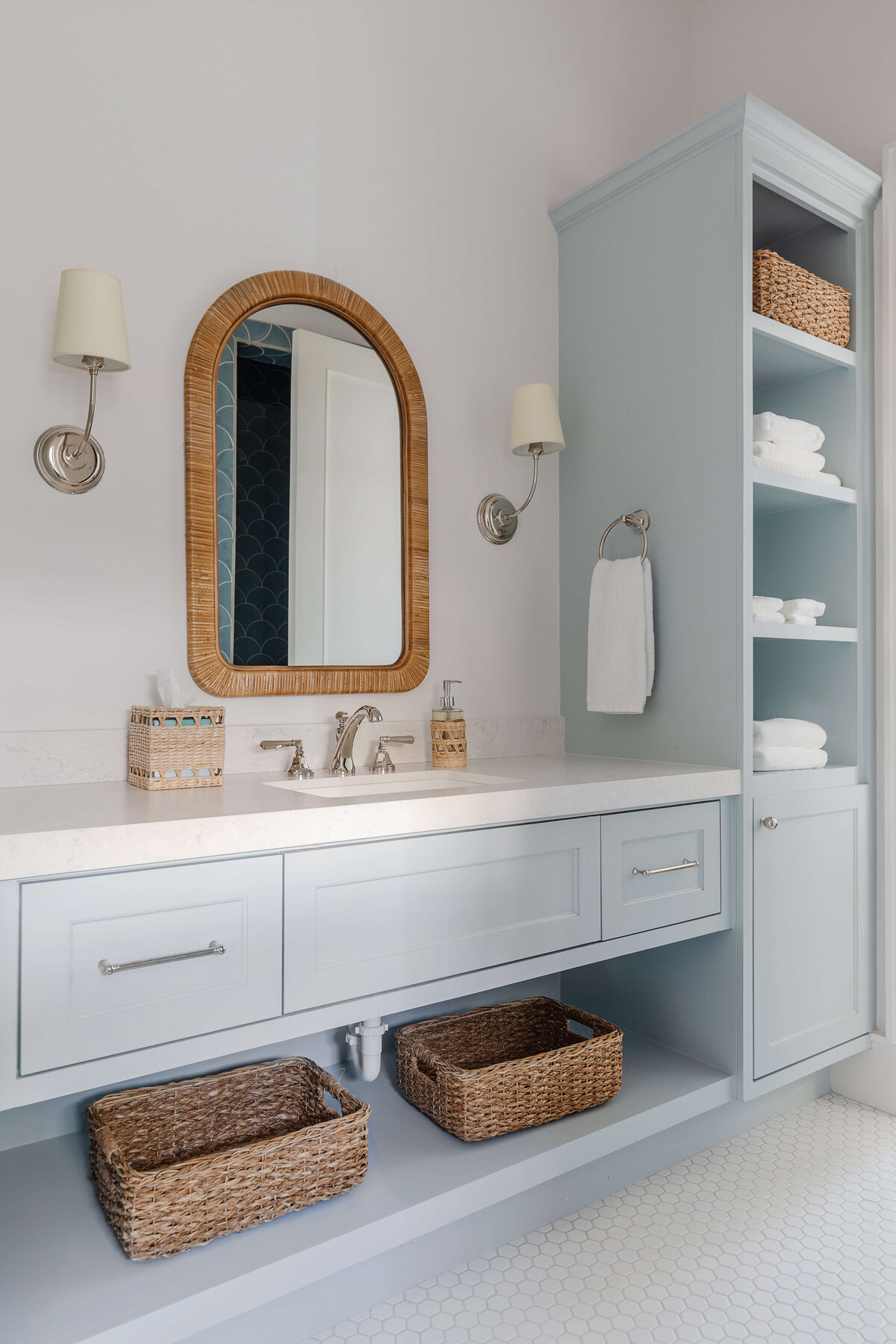oyster creek studios memorial new build light gray vanity with wooden accent mirror wicker baskets in bathroom