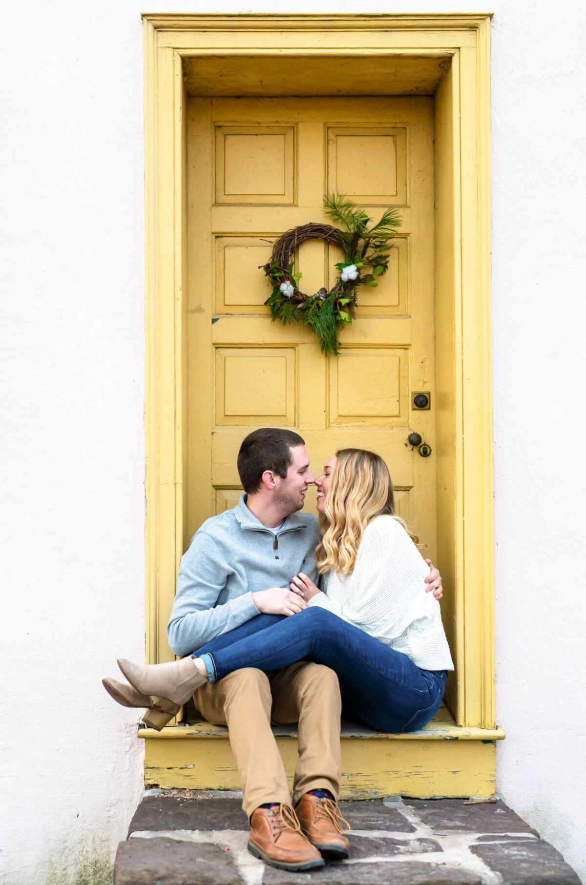 Man and woman snuggled in front of a yellow door in Washington crossing park