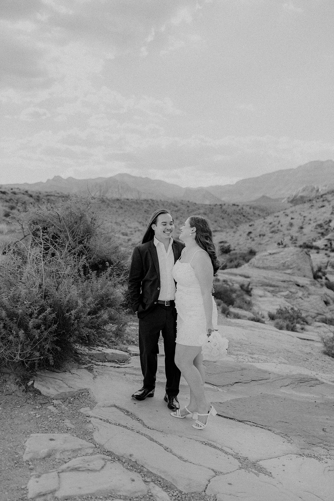 Engaged couple smiling with mountains in the background in Nevada