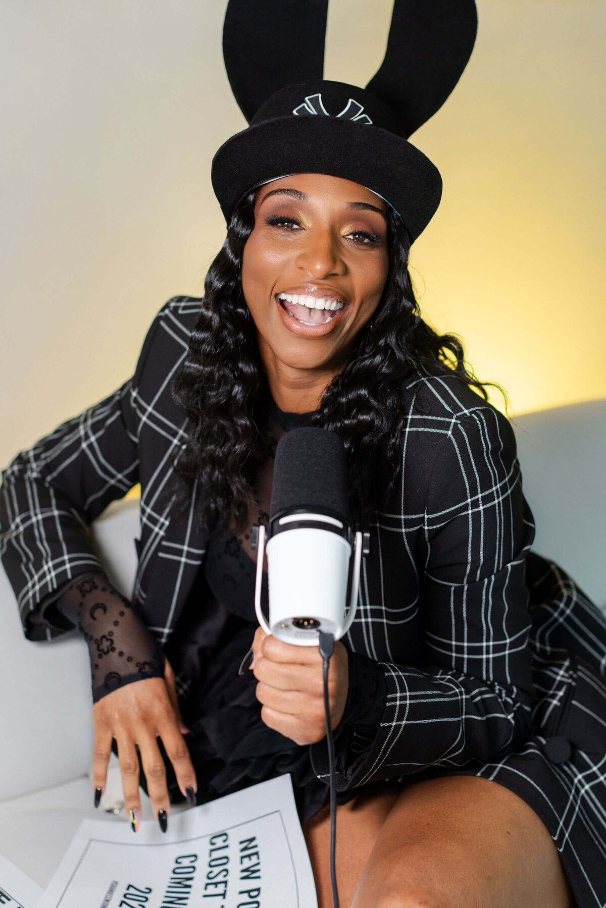 Shaniece Jones laughing and holding a podcast microphone.
