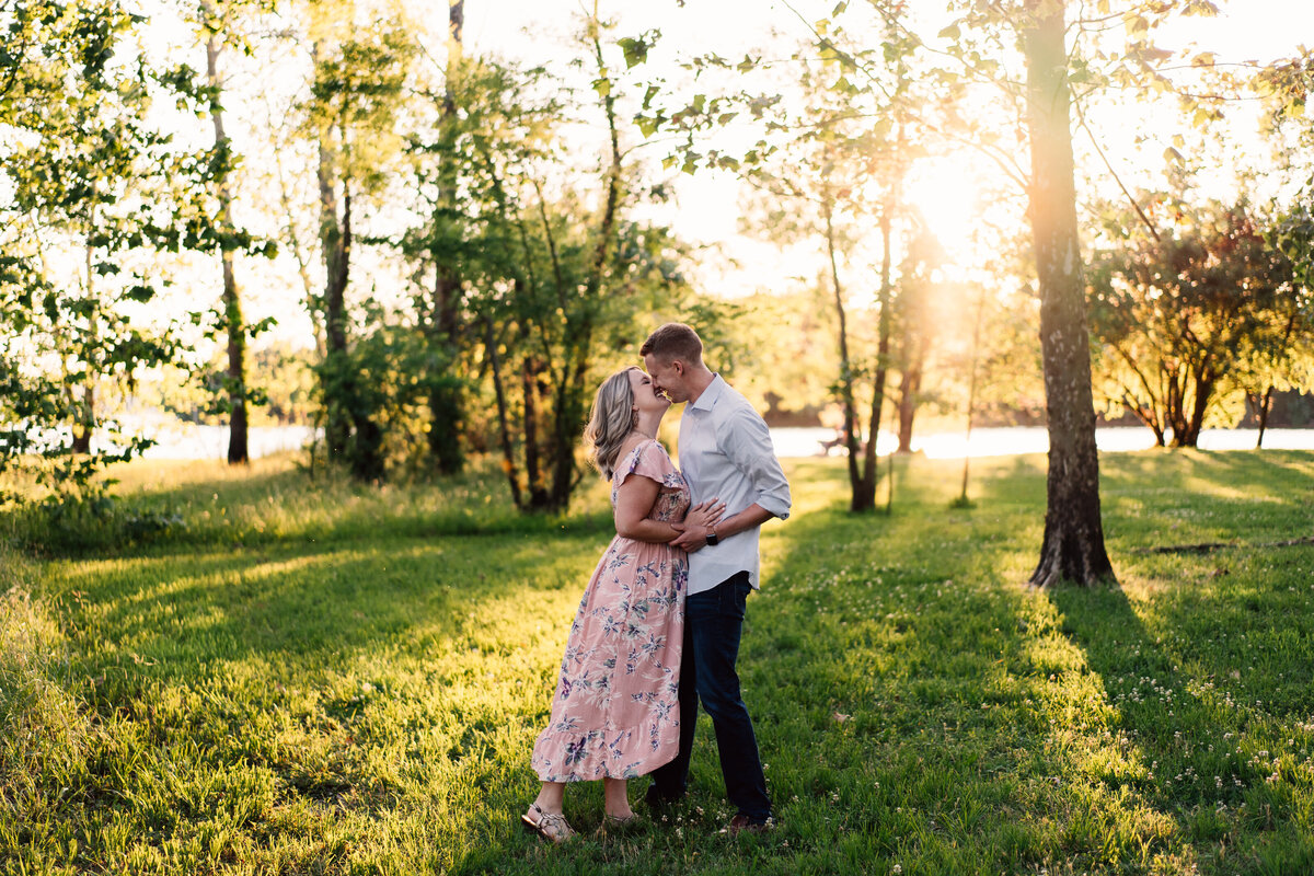 Couple almost kissing in forest during sunset