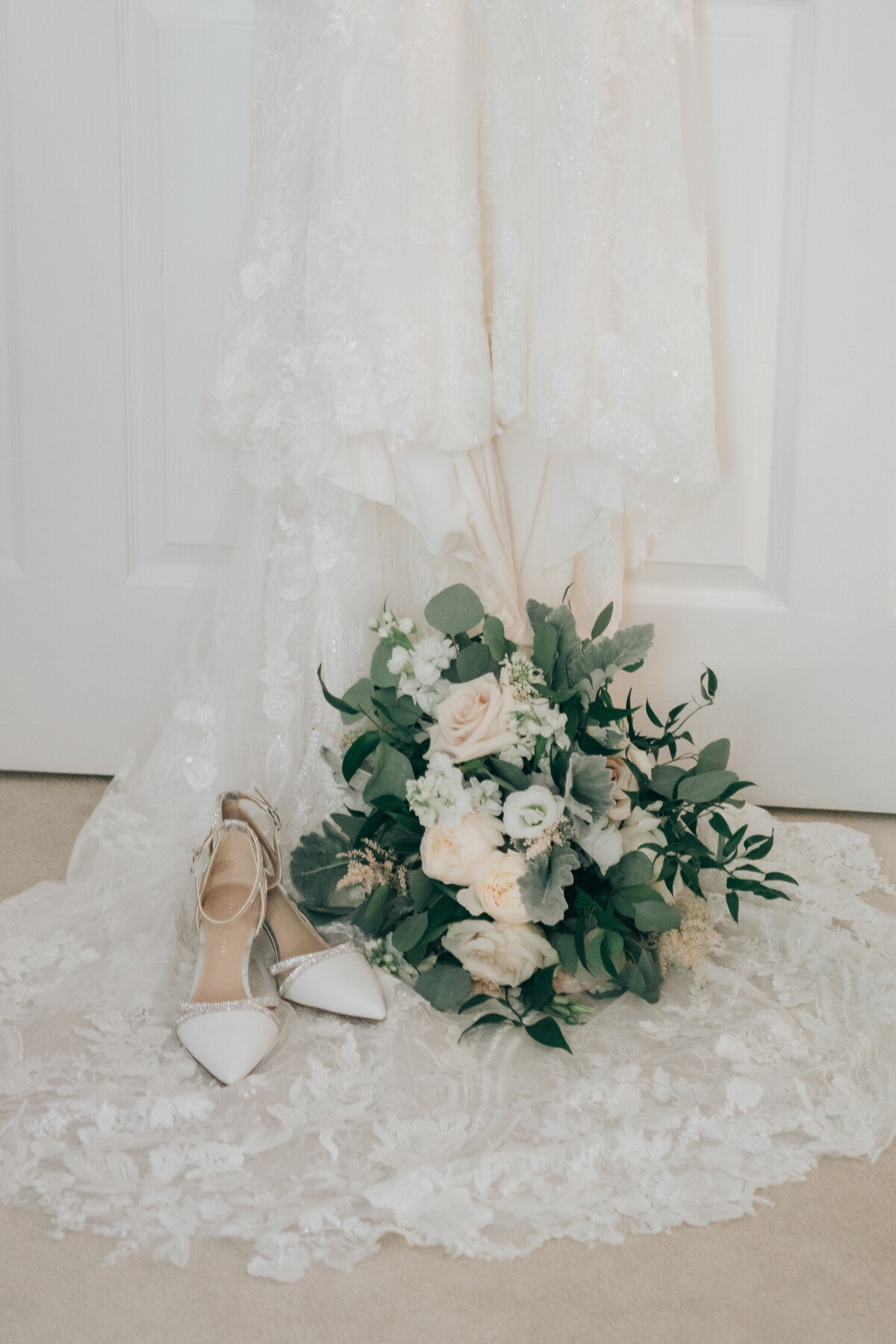 The bride's shoes and wedding bouquet on a lace wedding gown
