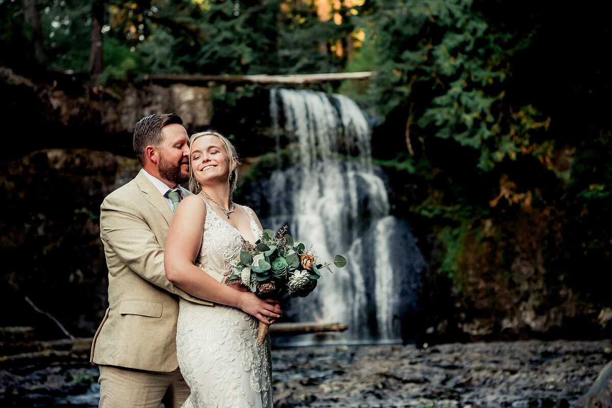 bride and groom enjoying waterfall