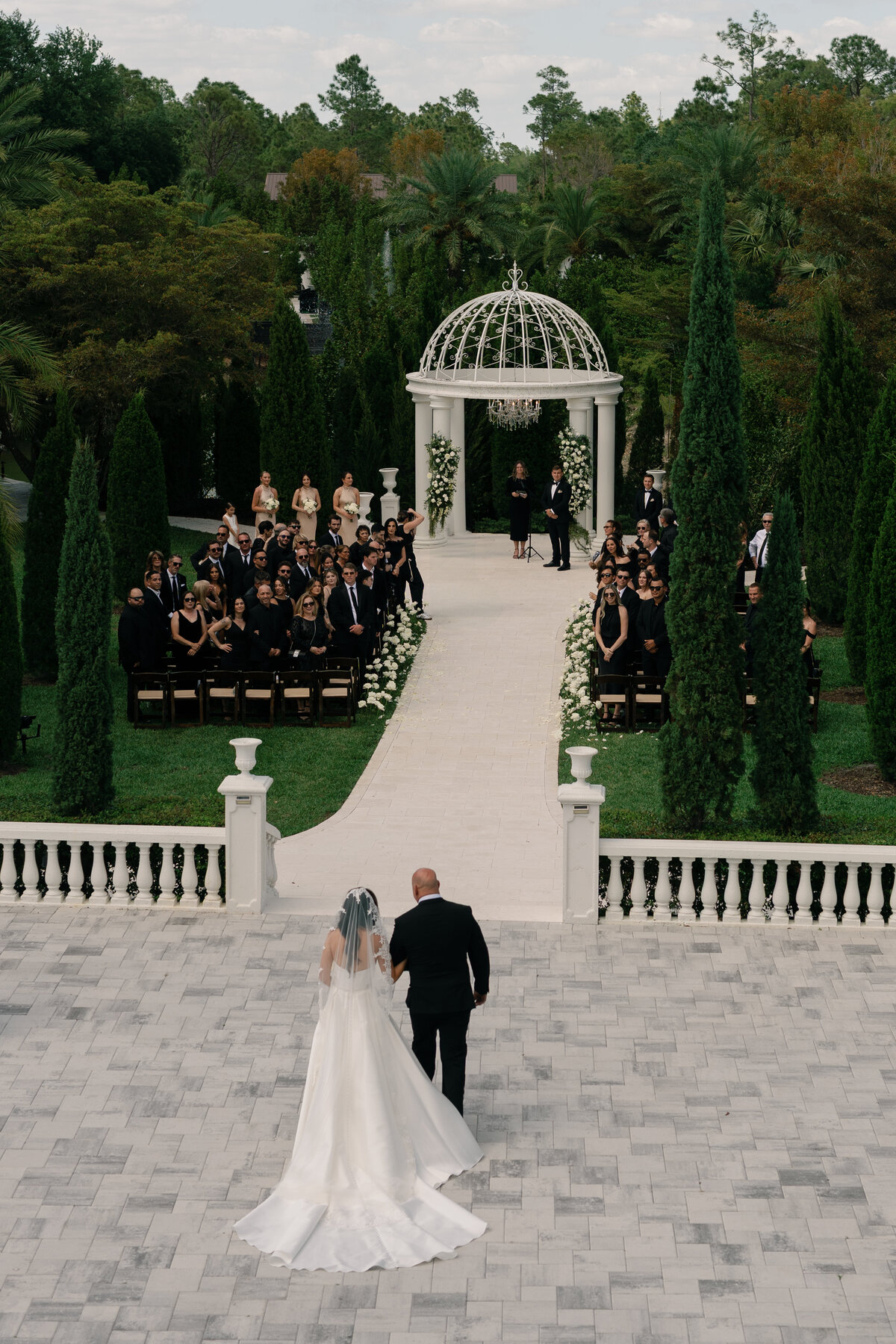 Outdoor wedding ceremony under white pergola at La Casa Toscana in Fort Myers