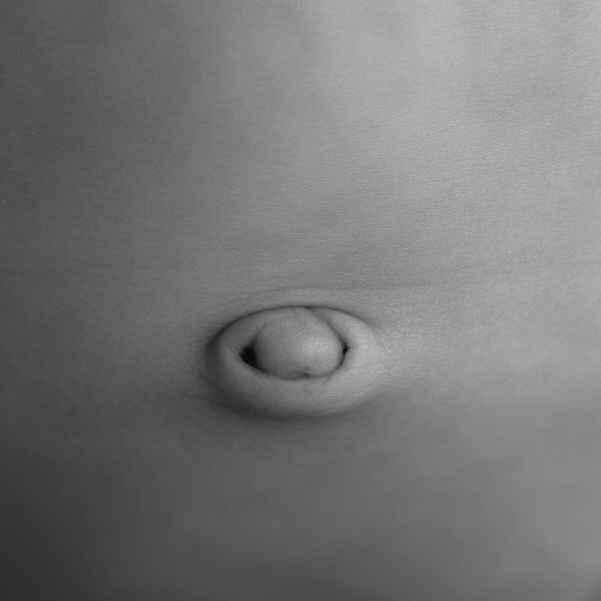 A beautiful detail of a newborn belly button—capturing the bond between womb and world.