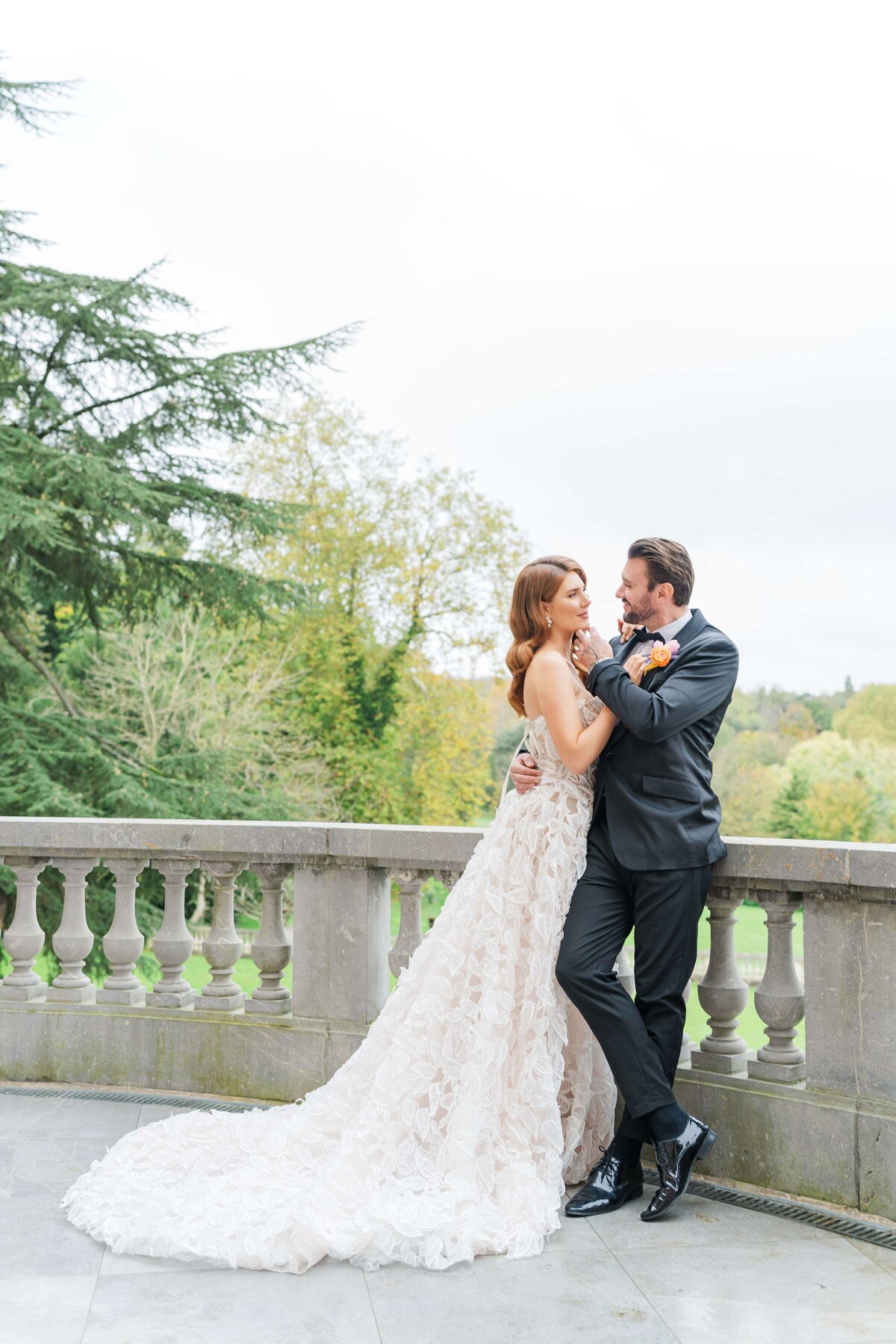 bride and groom stanting on theor wedding gowns looking at each other