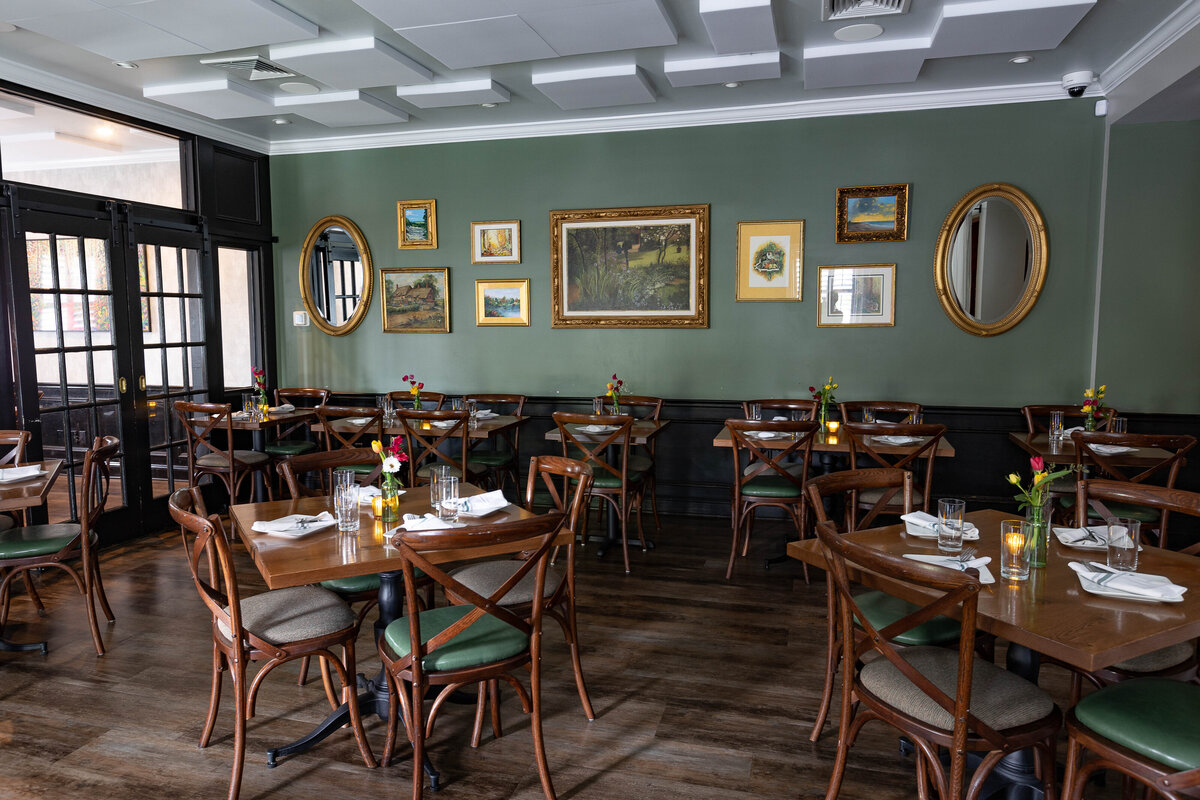 restaurant diningroom with green walls and wooden chairs