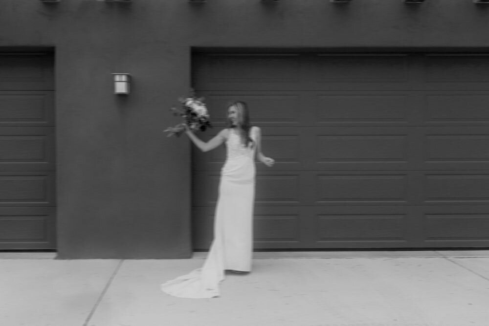 Bride holding bridal bouquet in front of art inspired home with minimalistic vibes with motion blur
