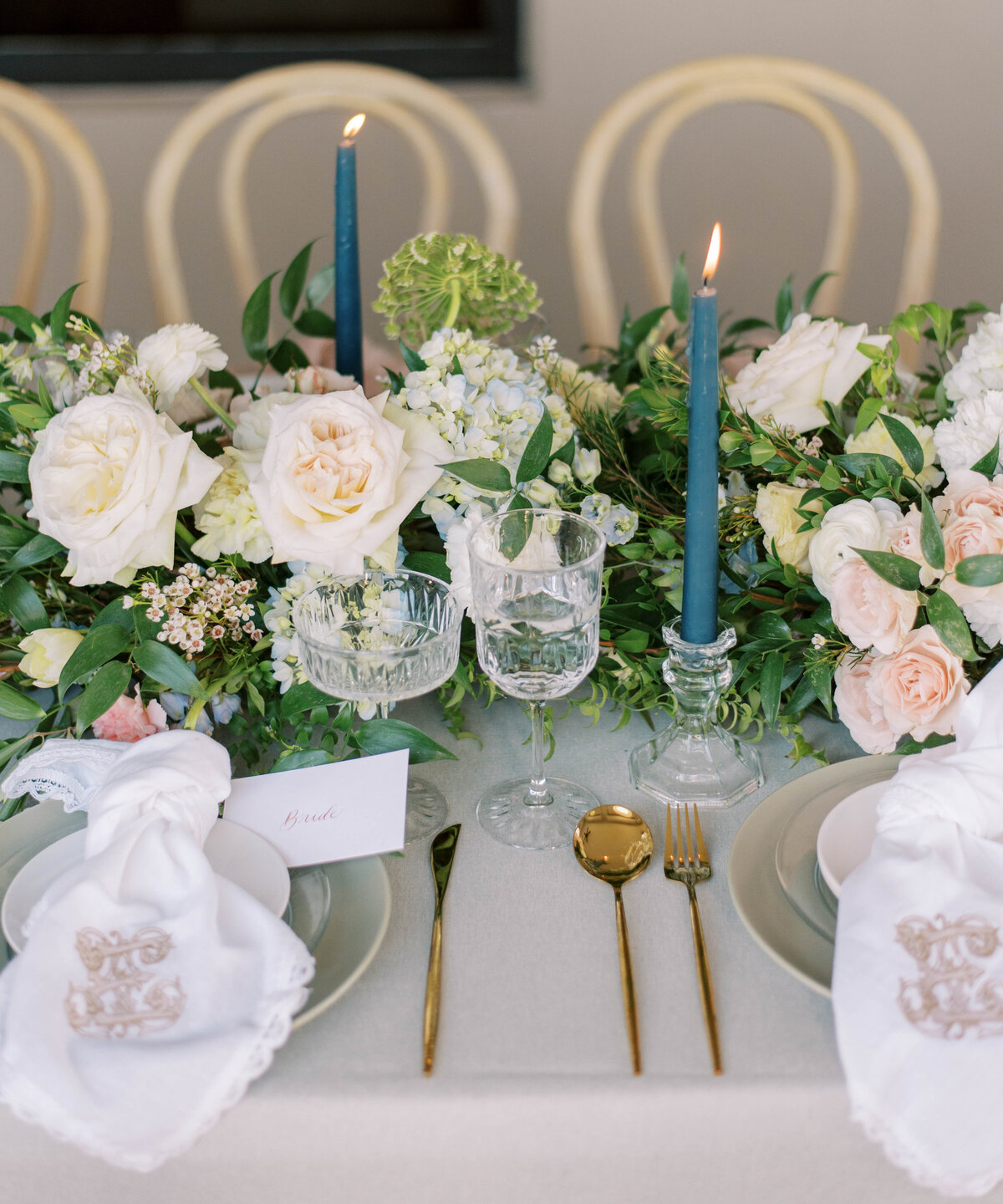 greenery and white floral centerpiece with blue candles at hotel zamora wedding