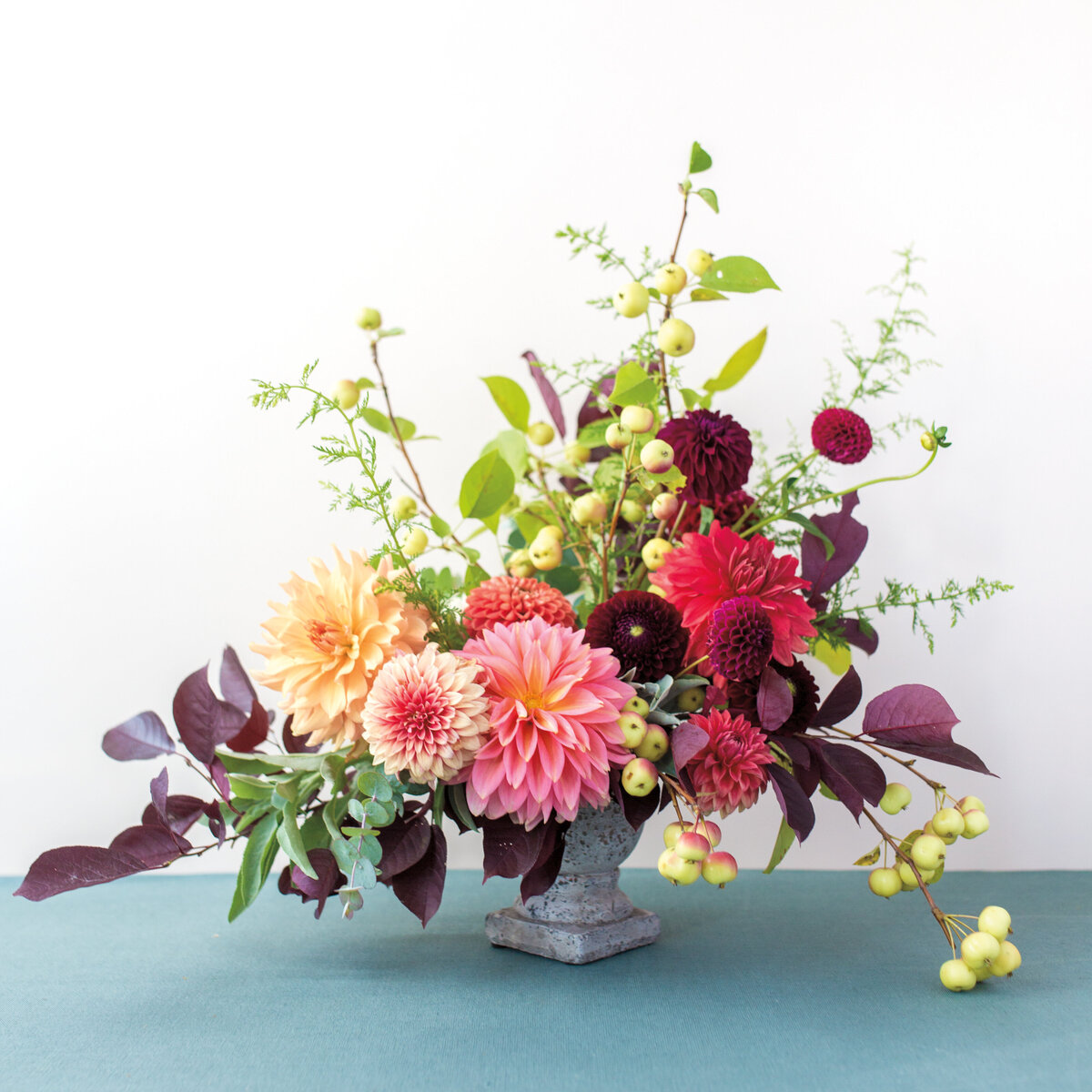 A bright organic floral arrangement with delicate branches at a Montreal wedding.