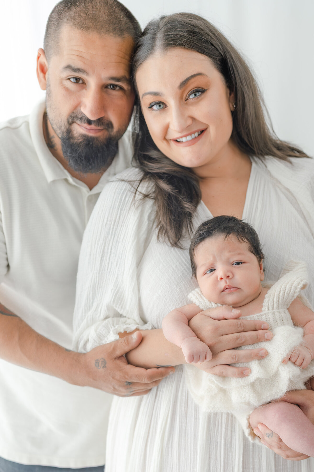 Parents holding baby during natural light Barrie newborn photography session 