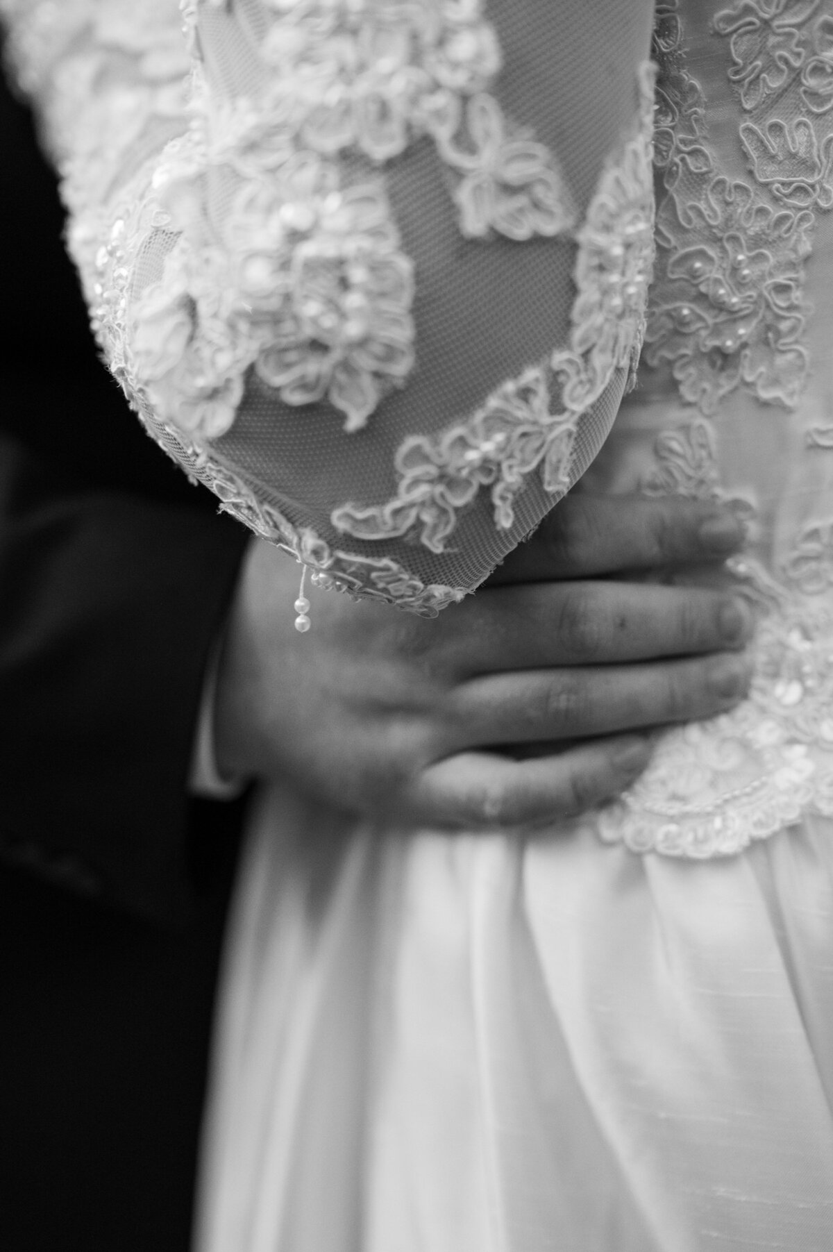 A close up of someone's hand around their partner's waist