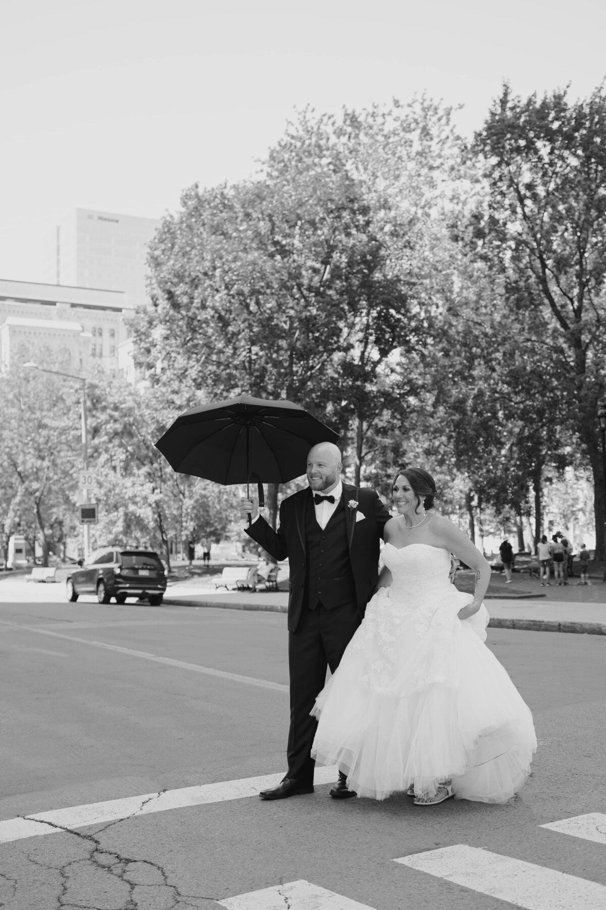 groom holding umbrella for bride
