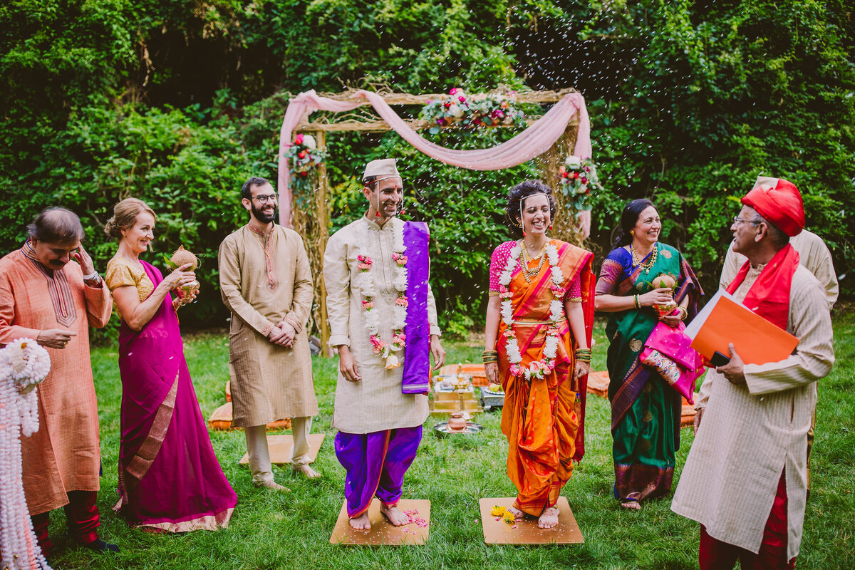 Rice being thrown at the indian bride and groom during their traditional maharashtrian hindu wedding ceremony at grounds for sculpture nj