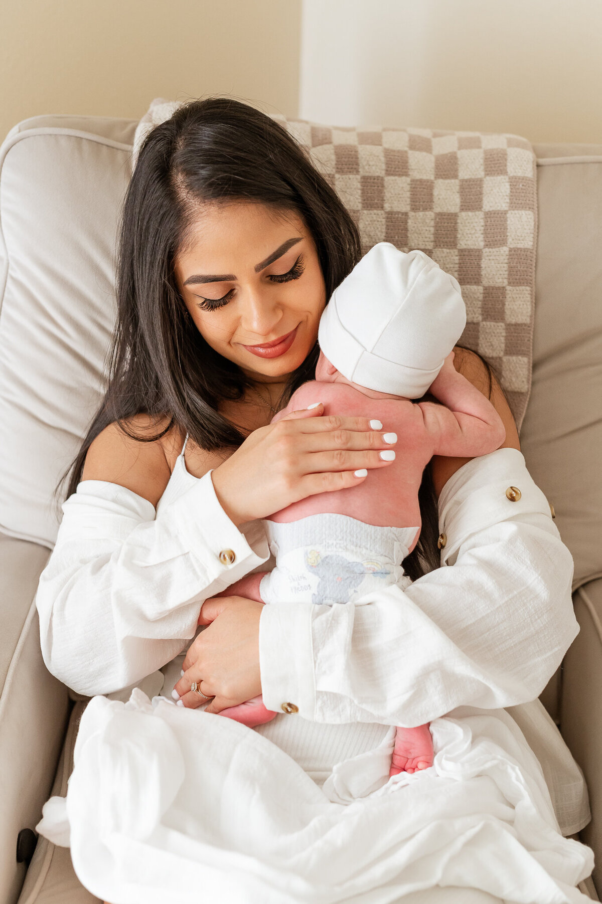 Lifestyle Newborn Session in Orlando. Mom is holding newborn in rocking chair