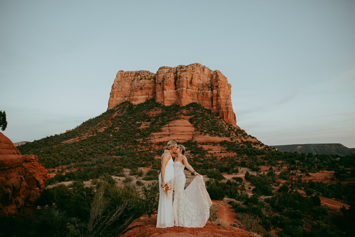 two brides stand together in front of courthouse vista in sedona