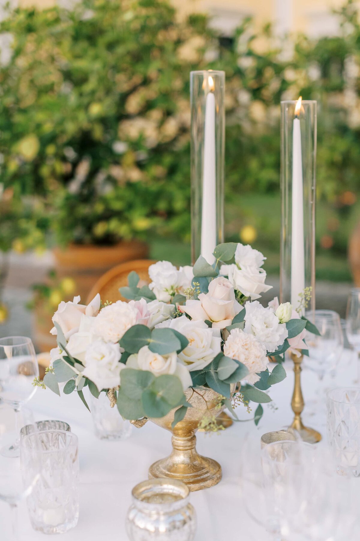 Pastellfärgat blomsterarrangemang på bröllop med vita rosor, rosa rosor och eucalyptus