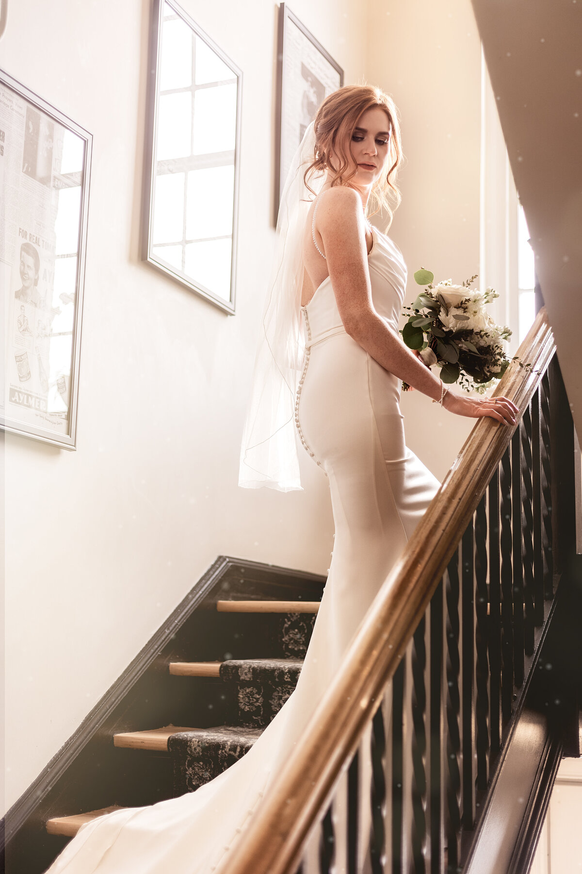 Bride poses on a staircase at the Inn on Officers Garden