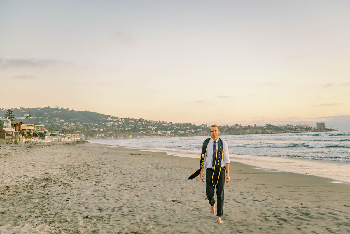 Cap and gown photoshoot for a UCSD graduate at La Jolla Shores beach