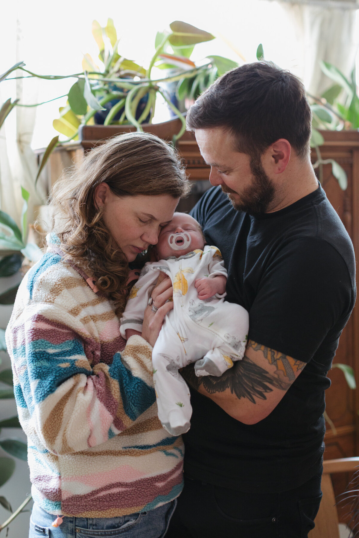 Parents hold their new baby during a newborn photoshoot at home in Portland, Oregon. 