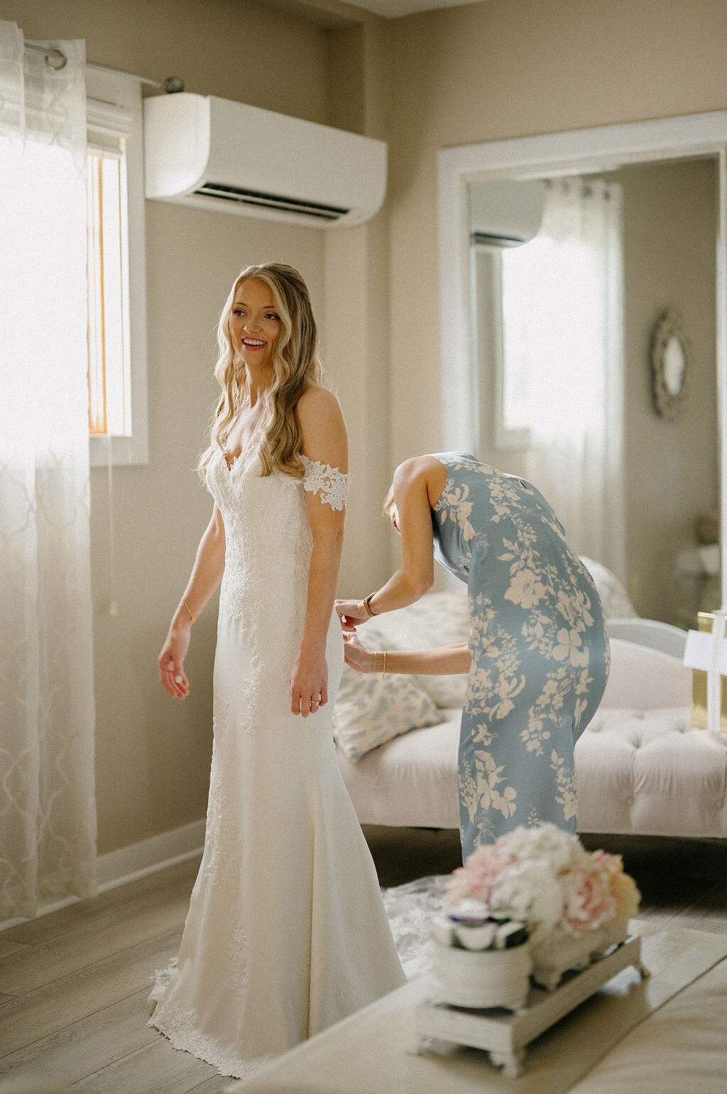 Bridesmaids helping the bride fix her wedding dress
