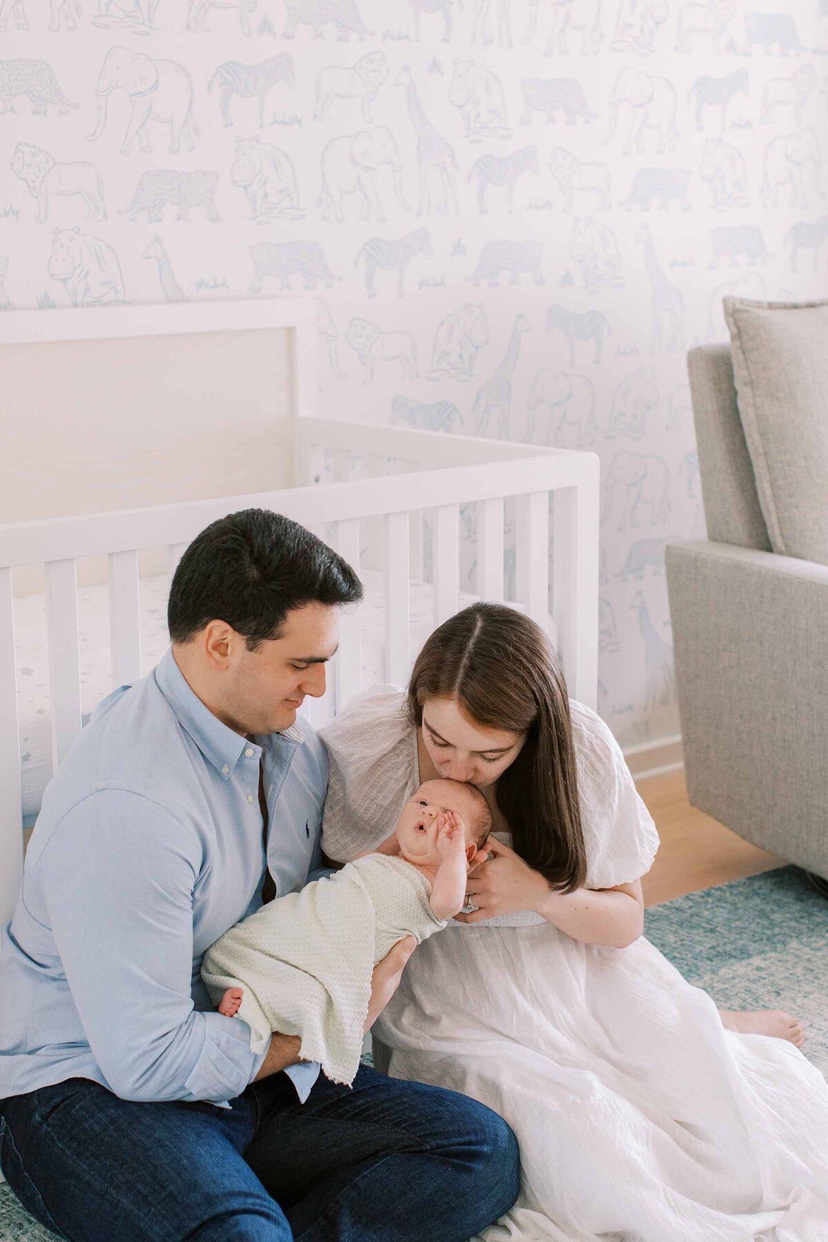Mom kissing baby's head while dad holds him