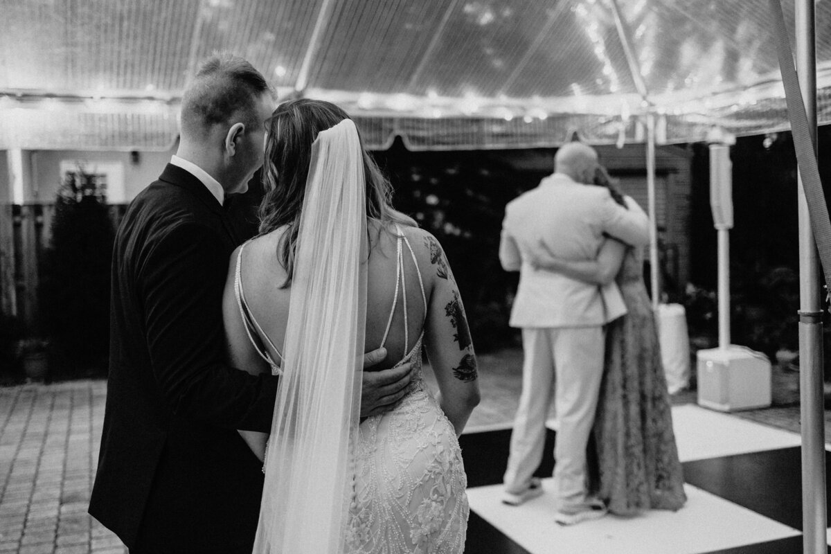 Bride and groom watching their guests dance together at their Jacksonville, Florida wedding reception.