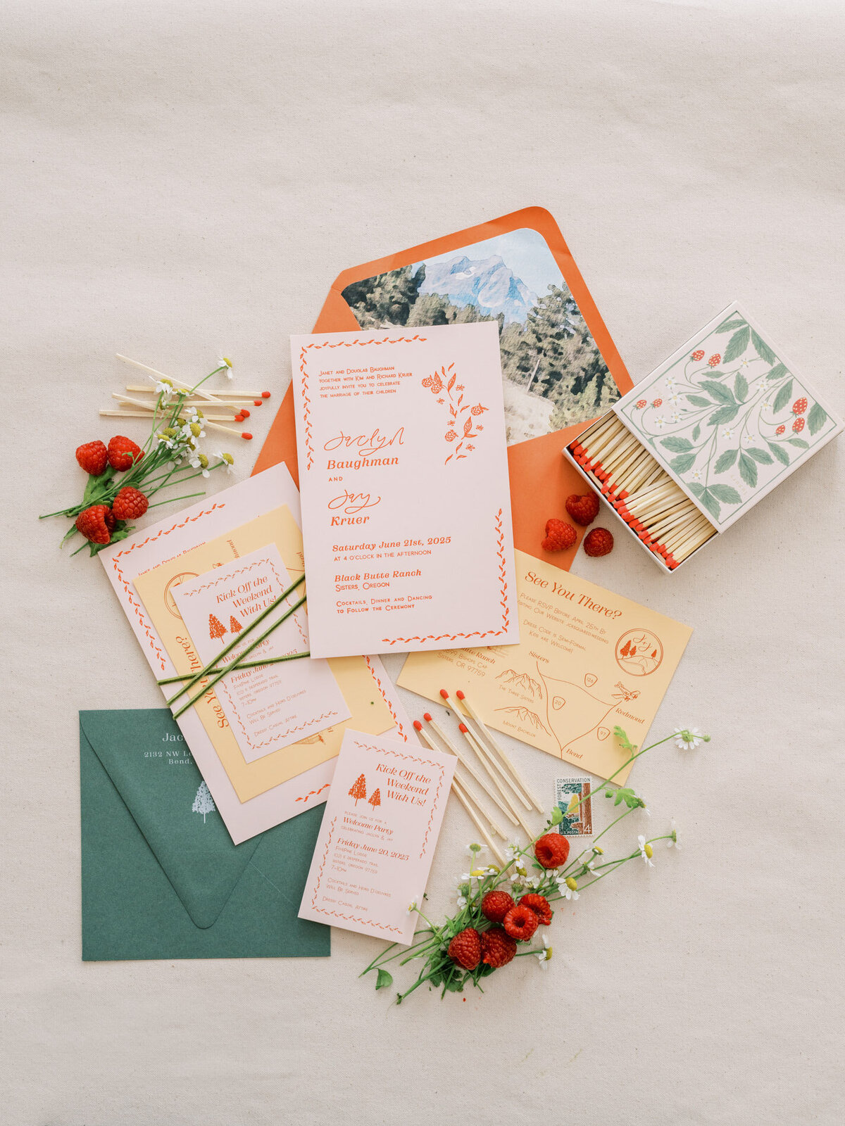 Wedding invitation flatlay with custom calligraphy details, florals, berries, matches and envelopes representing full service design and calligraphy by Life in Letters.