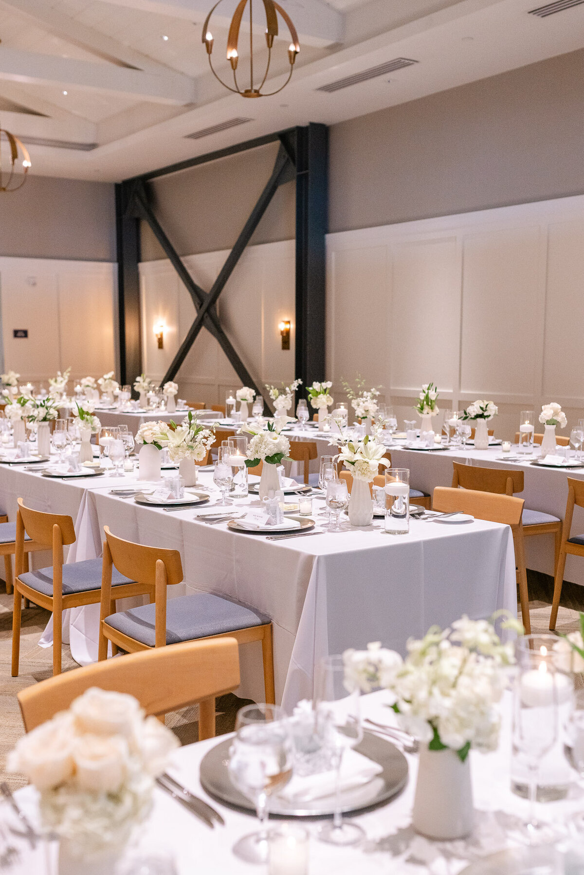 A sophisticated wedding reception setup with white florals, candlelit tables, and chic decor at Lido House in Newport Beach
