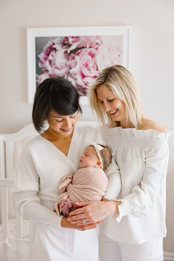 Two women pose with their new baby during their photo session.