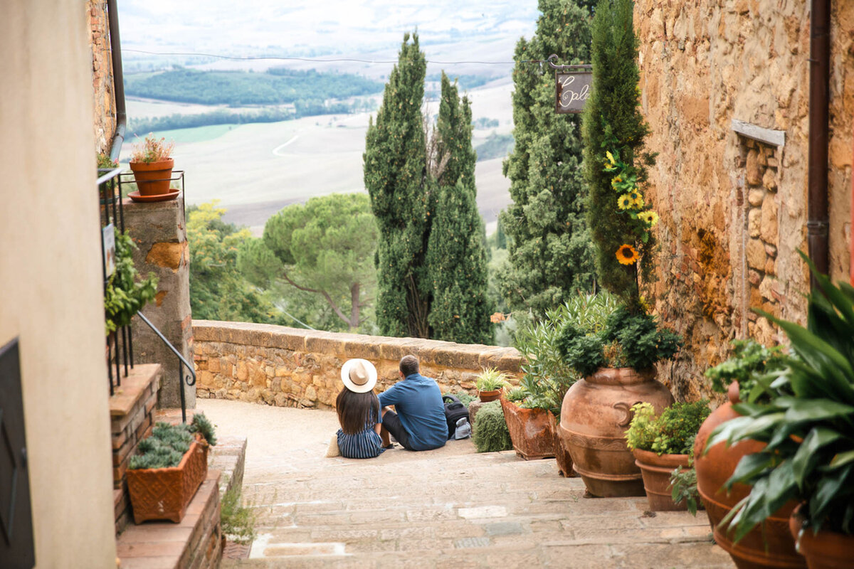iStock-1326118700 Rear view of a couple sitting on the stairs, Pienza, Italy