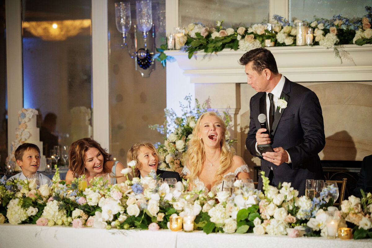 A groom giving a speech with people sitting next to them